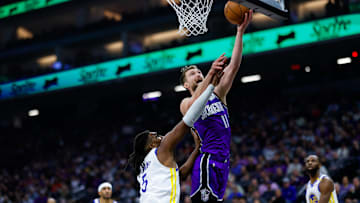 Jan 22, 2025; Sacramento, California, USA; Sacramento Kings forward Domantas Sabonis (11) drives to the basket against Golden State Warriors forward Kevon Looney (5) during the first quarter at Golden 1 Center. Mandatory Credit: Sergio Estrada-Imagn Images