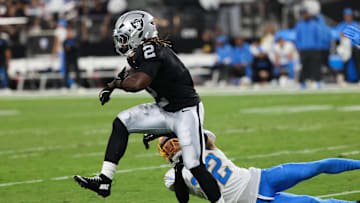 Las Vegas Raiders running back Ashton Jeanty (2) evades a tackle from Los Angeles Chargers safety Alohi Gilman (32) during the first quarter at Allegiant Stadium. 