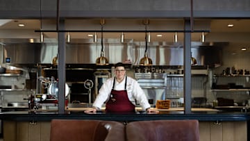 Britt Rescigno stands in front of Fiamma's open kitchen