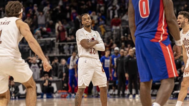A basketball player celebrating while wearing a white uniform.