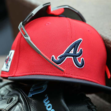 wMar 1, 2025; North Port, Florida, USA; A detail view of Atlanta Braves hat, sunglasses and glove in the dugout during the fifth inning at CoolToday Park. Mandatory Credit: Kim Klement Neitzel-Imagn Images