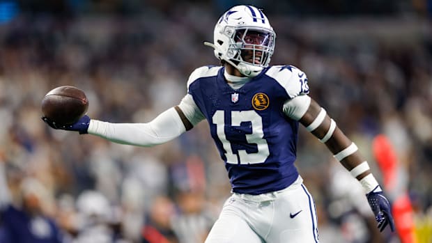 Dallas Cowboys linebacker DeMarvion Overshown (13) intercepts a pass and returns it for a touchdown in a game.