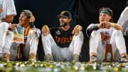 Jun 24, 2024; Omaha, NE, USA; Tennessee Volunteers center fielder Hunter Ensley (9), head coach Tony Vitello and third baseman Billy Amick (11) watch a video during postgame ceremonies after defeating the Texas A&M Aggies in the championship at Charles Schwab Field Omaha