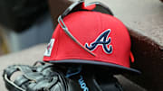 Mar 1, 2025; North Port, Florida, USA; A detail view of Atlanta Braves hat, sunglasses and glove in the dugout during the fifth inning at CoolToday Park. Mandatory Credit: Kim Klement Neitzel-Imagn Images