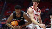 Jan 28, 2025; Salt Lake City, Utah, USA; Cincinnati Bearcats guard Josh Reed (10) rebounds the ball against Utah Utes forward Caleb Lohner (11) during the second half at Jon M. Huntsman Center. Mandatory Credit: Rob Gray-Imagn Images