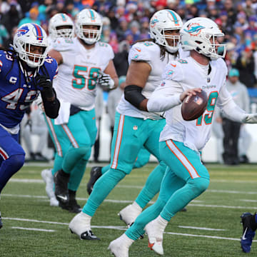 Miami Dolphins QB Skylar Thompson rolls away from pressure from Bills linebacker Tremaine Edmunds and Boogie Basham in the 2022 playoff game at Buffalo.