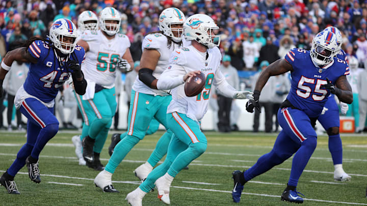 Miami Dolphins QB Skylar Thompson rolls away from pressure from Bills linebacker Tremaine Edmunds and Boogie Basham in the 2022 playoff game at Buffalo.