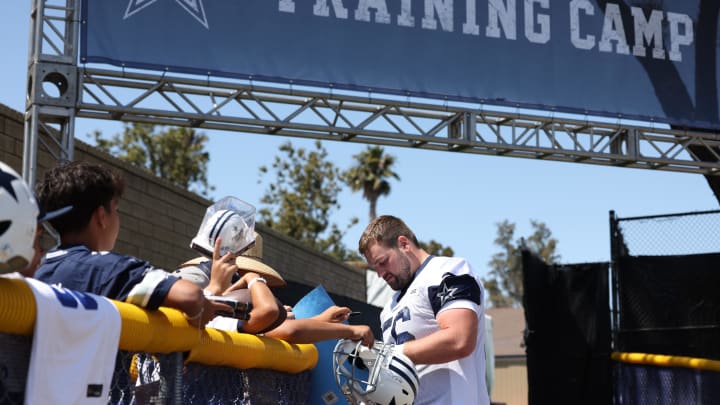 Jul 26, 2024; Oxnard, CA, USA; Dallas Cowboys guard Cooper Beebe (56) signs autographs during training camp at the River Ridge Playing Fields in Oxnard, California.