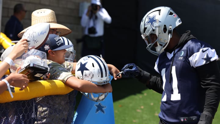 Jul 26, 2024; Oxnard, CA, USA; Dallas Cowboys linebacker Micah Parsons (11) signs autographs during training camp at the River Ridge Playing Fields in Oxnard, Californian.  