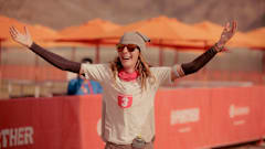 Ultrarunner Camille Herron raises her hands while running a six-day marathon. 