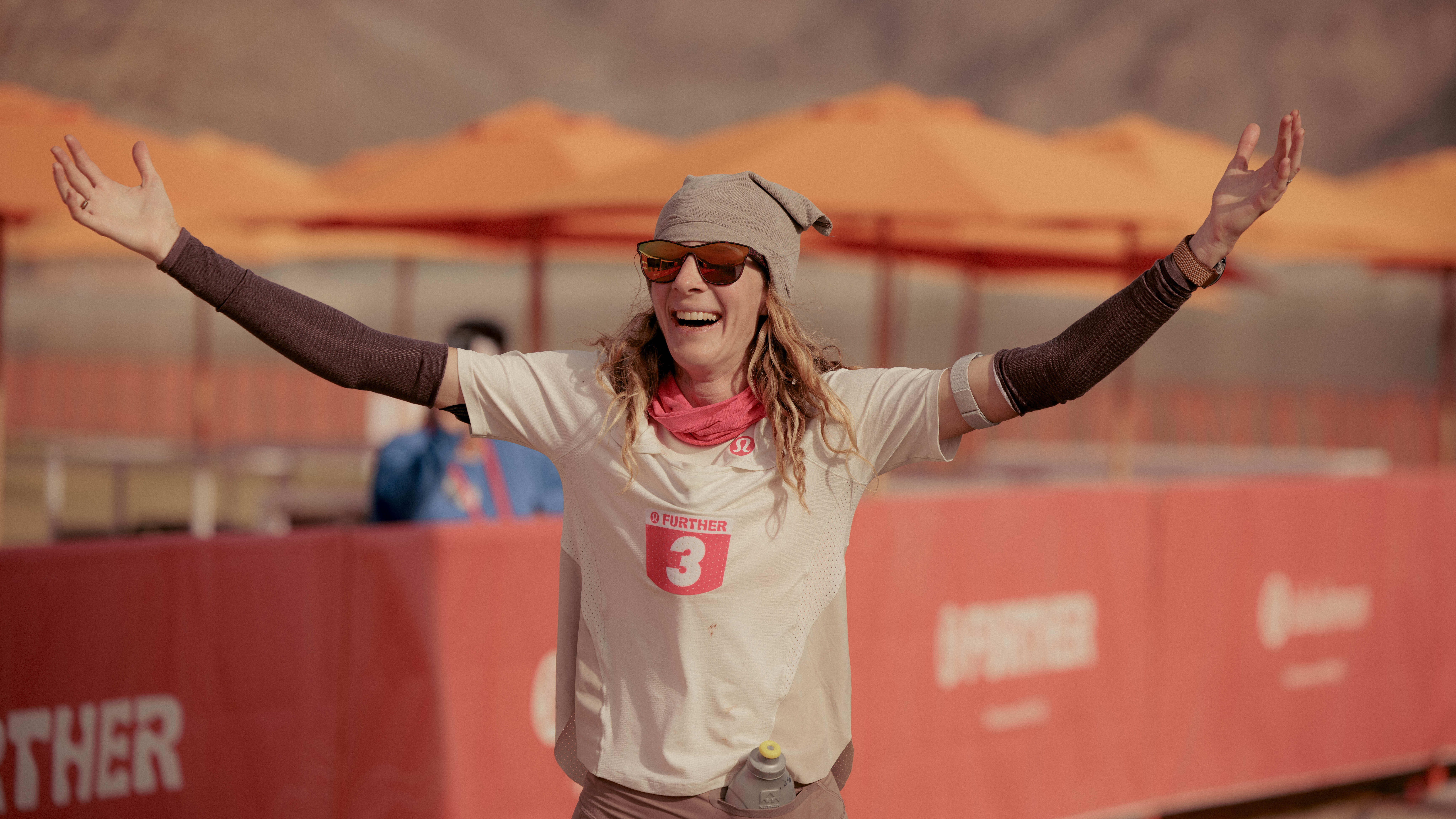 Ultrarunner Camille Herron raises her hands while running a six-day marathon. 