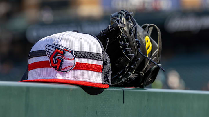 Jul 8, 2024; Detroit, Michigan, USA; A Cleveland Guardians baseball cap and glove sit on the dugout rail before the game against the Detroit Tigers at Comerica Park. Mandatory Credit: David Reginek-Imagn Images