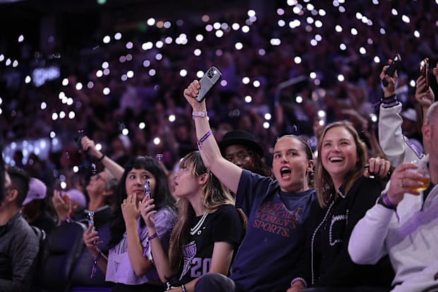 Golden State Valkyries fans hold their phones during a timeout. 