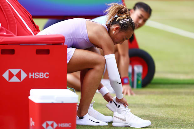 Qinwen Zheng changes shoes during a match.