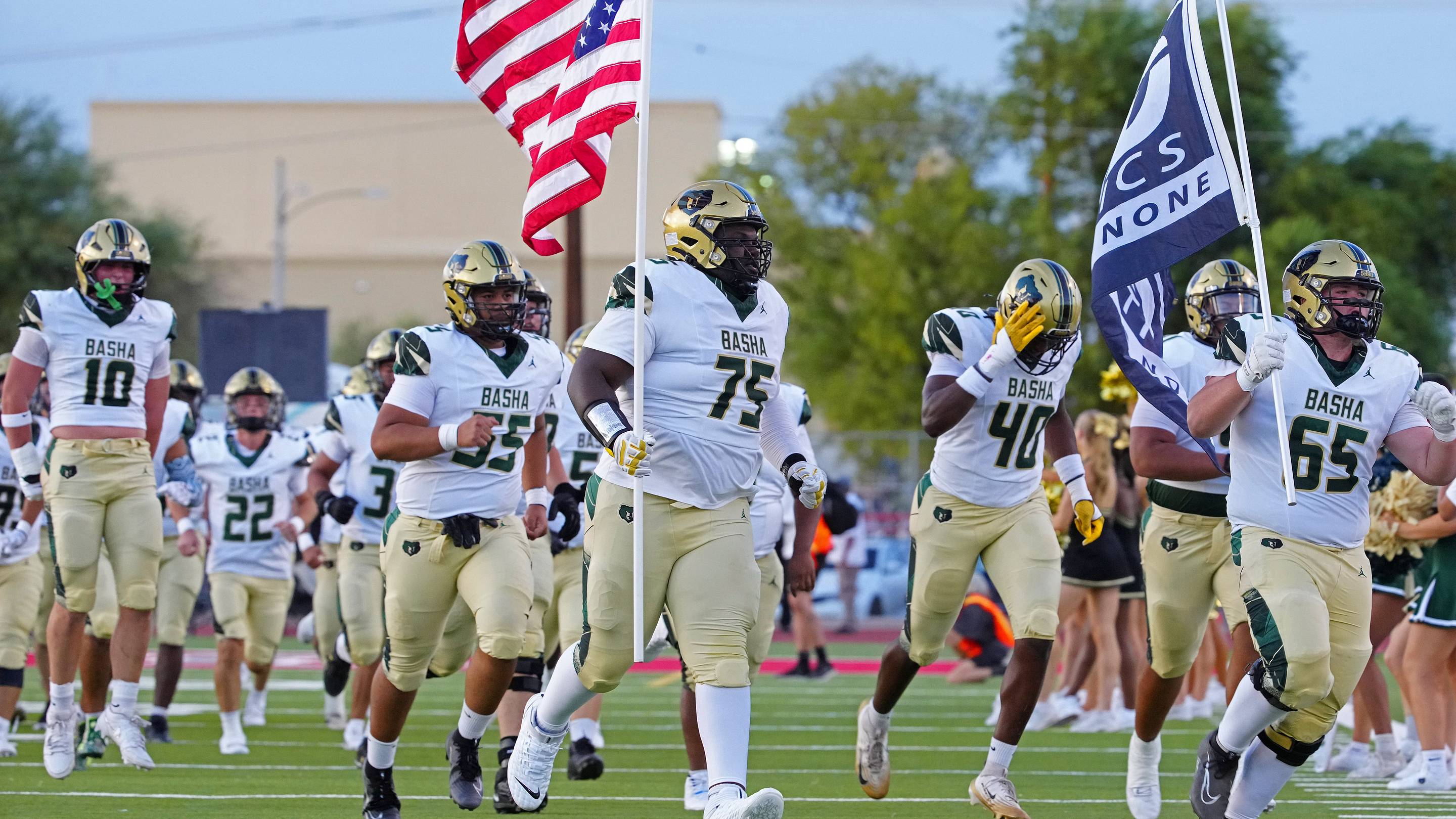 Basha tackle Dajohn Yarborough (75) carries out the American flag before a 2025 games against Brophy Prep.