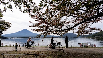 Cyclists riding by Japan's Mount Fuji 