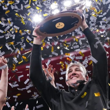 Purdue coach Matt Painter holds up the 2024 NCAA men's tournament Midwest Regional trophy 