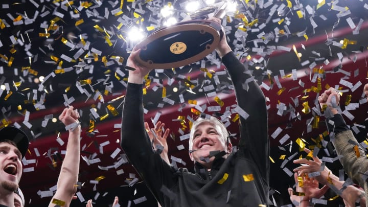 Purdue coach Matt Painter holds up the 2024 NCAA men's tournament Midwest Regional trophy 