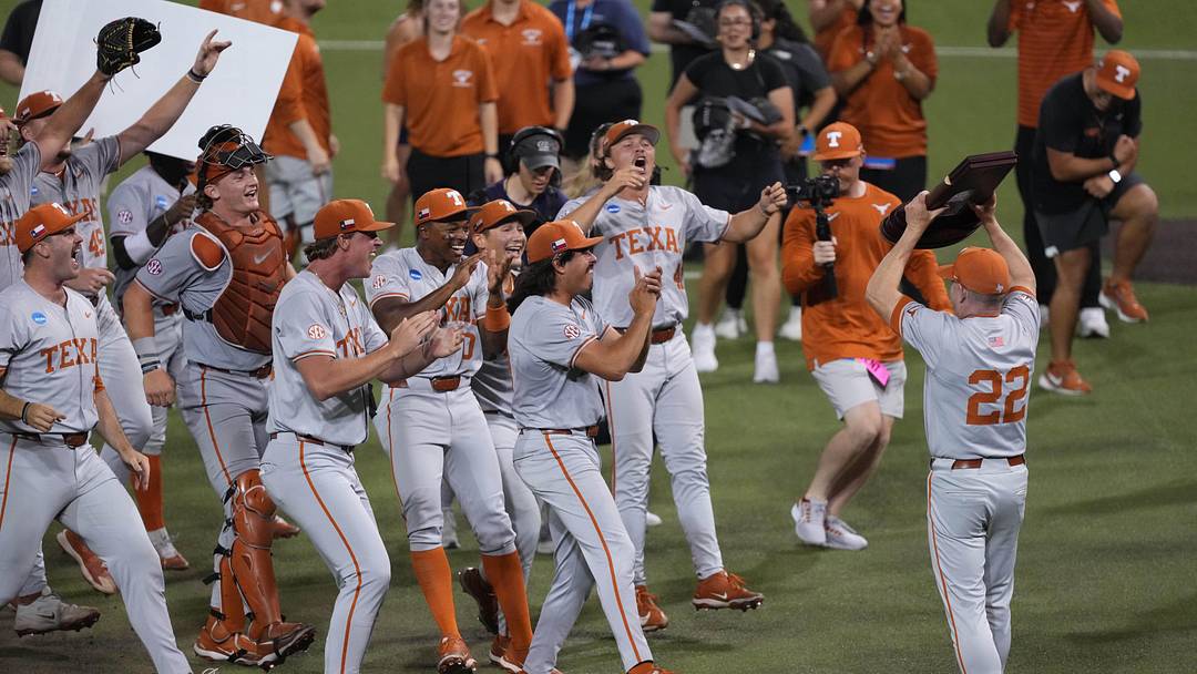 Jun 7, 2026; Austin, TX, USA; Texas Longhorns Head Coach Jim Schlossnagle holds the trophy ahead of players after closing out a Super Regional game over the Oregon Ducks at UFCU Disch-Falk field in Austin, Texas. Mandatory Credit: Scott Wachter-Imagn Images