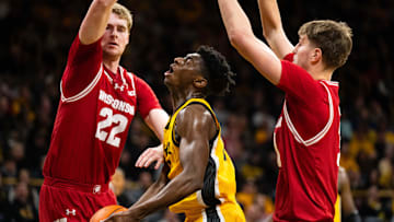 Feb 8, 2025; Iowa City, Iowa, USA; Iowa Hawkeyes guard Drew Thelwell (3) goes down against Wisconsin Badgers forward Steven Crowl (22) and forward Nolan Winter (31) during the second half at Carver-Hawkeye Arena. Mandatory Credit: Dylan Widger-Imagn Images