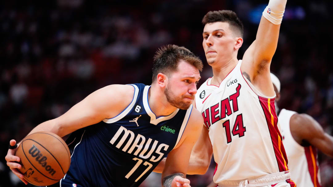 Apr 1, 2023; Miami, Florida, USA; Dallas Mavericks guard Luka Doncic (77) dribbles the ball past Miami Heat guard Tyler Herro (14) during the third quarter at Miami-Dade Arena. Mandatory Credit: Rich Storry-USA TODAY Sports