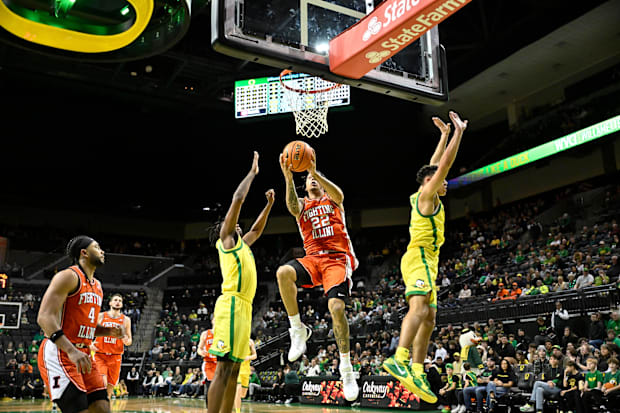 Illinois Fighting Illini guard Tre White (22) drives to the basket past Oregon Ducks guard Jackson Shelstad (3).