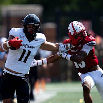Cincinnati Bearcats tight end Joe Royer (11) stiff arms Miami Redhawks linebacker Oscar McWood (23) before the play is called back for holding in the fourth quarter of the College Football game at Yager Stadium in Cincinnati on Saturday, Sept. 14, 2024.