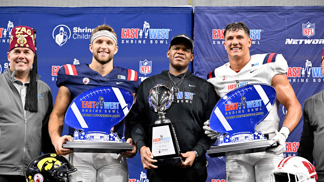 Jan 27, 2026; Frisco, TX, USA; (from left) West quarterback Mark Gronowski (11) and West head coach Lunda Wells and East edge rusher Mason Reiger (22) pose with their trophies after the game at the Ford Center at the Star.  