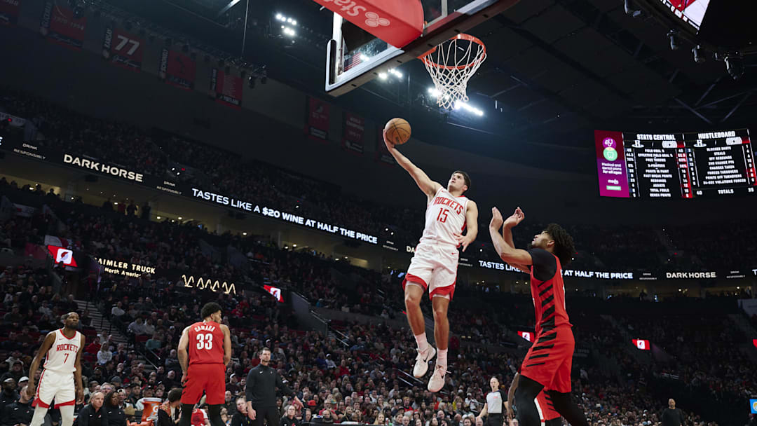 Jan 9, 2026; Portland, Oregon, USA; Houston Rockets guard Reed Sheppard (15) scores a basket during the first half against Portland Trail Blazers guard Shaedon Sharpe (17) at Moda Center. Mandatory Credit: Troy Wayrynen-Imagn Images