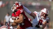 Wisconsin Badgers linebacker Mason Posa (8) grabs the helmet of Indiana Hoosiers tight end Riley Nowakowski (37)
