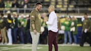 Nov 14, 2025; Eugene, Oregon, USA; Oregon Ducks head coach Dan Lanning, left, and Minnesota Golden Gophers head coach P.J. Fleck talk before a game at Autzen Stadium. Mandatory Credit: Troy Wayrynen-Imagn Images