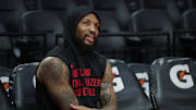 Nov 3, 2025; Portland, Oregon, USA;  Portland Trail Blazers guard Damian Lillard (0) watches teammates warm up before a game against the Los Angeles Lakers at Moda Center. Mandatory Credit: Troy Wayrynen-Imagn Images