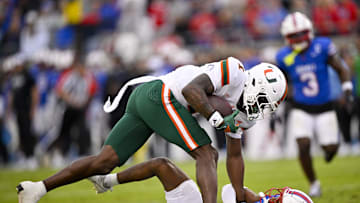 Nov 1, 2025; Dallas, Texas, USA;  Miami Hurricanes wide receiver Joshisa Trader (1) dives over SMU Mustangs cornerback Marcellus Barnes Jr. (8) for a touchdown during the first quarter at Gerald J. Ford Stadium. Mandatory Credit: Jerome Miron-Imagn Images