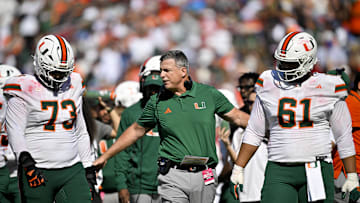Nov 1, 2025; Dallas, Texas, USA;  Miami Hurricanes head coach Mario Cristobal talks to offensive lineman Anez Cooper (73) and offensive lineman Francis Mauigoa (61) during the second half against the SMU Mustangs at Gerald J. Ford Stadium. Mandatory Credit: Jerome Miron-Imagn Images