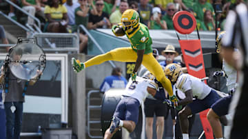 Aug 30, 2025; Eugene, Oregon, USA; Oregon Ducks wide receiver Dakorien Moore (1) leaps over Montana State Bobcats defensive back Bryant Meredith (6) during the first half at Autzen Stadium. Mandatory Credit: Troy Wayrynen-Imagn Images