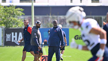 Jul 28, 2025; Foxborough, MA, USA; New England Patriots head coach Mike Vrabel (red sleeves and defensive coordinator Terrell Williams (blue pants) watch the team during training camp at Gillette Stadium. Mandatory Credit: Eric Canha-Imagn Images