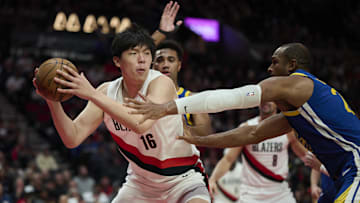 Oct 14, 2025; Portland, Oregon, USA; Portland Trail Blazers center Yang Hansen (16) controls the ball during the second half against Golden State Warriors center/forward Al Horford (20) at Moda Center. Mandatory Credit: Troy Wayrynen-Imagn Images