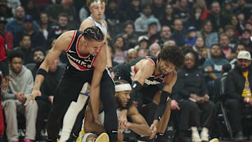 Apr 11, 2025; Portland, Oregon, USA; Golden State Warriors guard Moses Moody (4) gets tied up during the first half against Portland Trail Blazers forward Toumani Camara (33), left, and guard Matisse Thybulle (4) at Moda Center. Mandatory Credit: Troy Wayrynen-Imagn Images