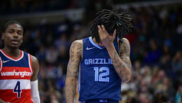 Jan 29, 2022; Memphis, Tennessee, USA; Memphis Grizzlies guard Ja Morant (12) reacts to being hit in the face during the second half against the Washington Wizards at the FedExForum. Mandatory Credit: Jerome Miron-Imagn Images