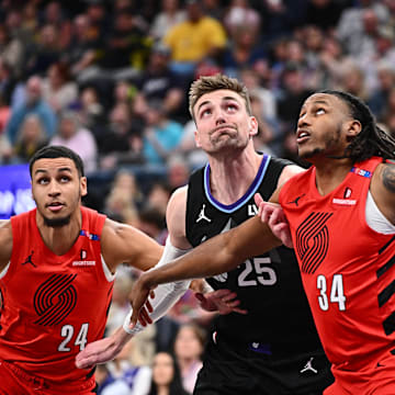 Apr 9, 2025; Salt Lake City, Utah, USA;  Utah Jazz center Micah Potter (25) is boxed out beneath the basket by Portland Trail Blazers forward Kris Murray (24) and forward Jabari Walker (34) in the first half at Delta Center. Mandatory Credit: Jamie Sabau-Imagn Images