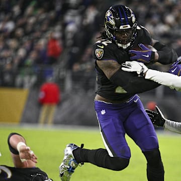 Dec 1, 2024; Baltimore, Maryland, USA; Baltimore Ravens running back Derrick Henry (22) rushes through Philadelphia Eagles cornerback Eli Ricks (23) tackle attempt during the first half at M&T Bank Stadium.  