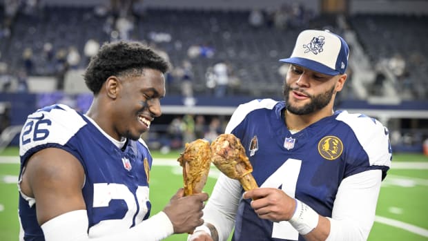 DaRon Bland (26) and quarterback Dak Prescott (4) eat turkey legs after the Cowboys victory over the Washington Commanders 