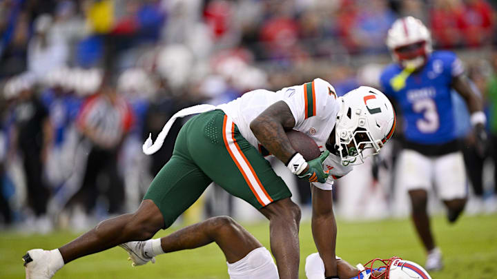 Nov 1, 2025; Dallas, Texas, USA;  Miami Hurricanes wide receiver Joshisa Trader (1) dives over SMU Mustangs cornerback Marcellus Barnes Jr. (8) for a touchdown during the first quarter at Gerald J. Ford Stadium. Mandatory Credit: Jerome Miron-Imagn Images
