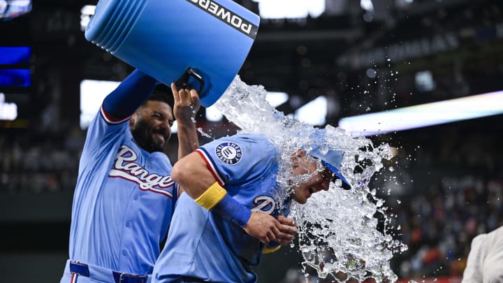 Sep 1, 2024; Arlington, Texas, USA; Texas Rangers third baseman Josh Jung (6) is doused with water by second baseman Marcus Semien (2) after Jung hits a game winning three run walk-off home run during the tenth inning against the Oakland Athletics at Globe Life Field. 