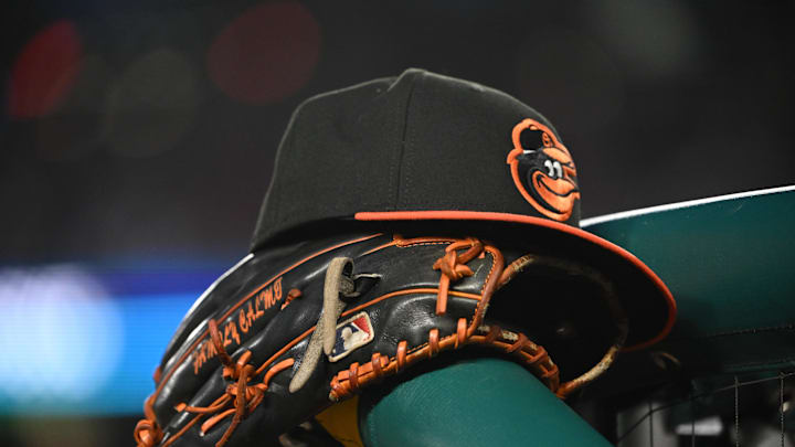 May 8, 2024; Washington, District of Columbia, USA; A Baltimore Orioles hat and glove rest on the dugout rail during a game against the Washington Nationals at Nationals Park. Mandatory Credit: Rafael Suanes-Imagn Images