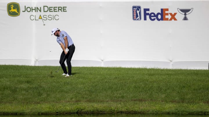 Cameron Young hits over the water hazard on the 18th hole during the third round of the 2023 John Deere Classic.