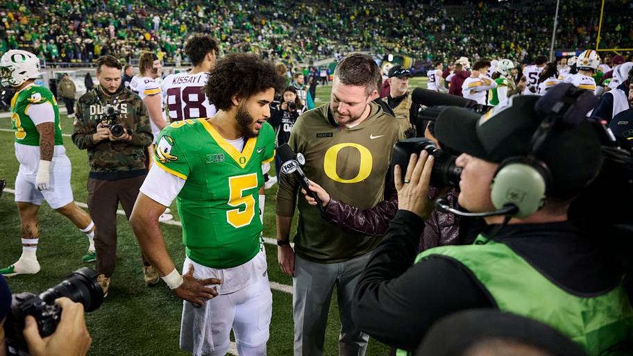 Oregon Ducks quarterback Dante Moore and coach Dan Lanning talk talk to a reporter after a game against Minnesota.