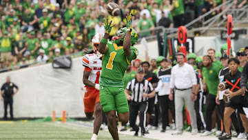 Sep 6, 2025; Eugene, Oregon, USA; Oregon Ducks wide receiver Dakorien Moore (1) catches a touchdown pass during the first half against Oklahoma State Cowboys cornerback Kale Smith (10) at Autzen Stadium. Mandatory Credit: Troy Wayrynen-Imagn Images