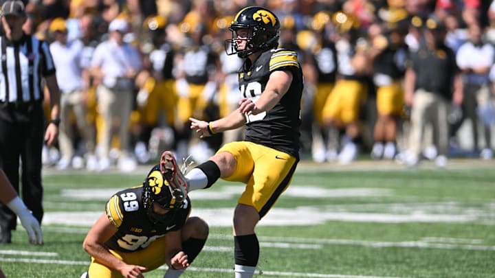 Aug 31, 2024; Iowa City, Iowa, USA; Iowa Hawkeyes place kicker Drew Stevens (18) kicks an extra point as punter Ty Nissen (99) holds during the fourth quarter against the Illinois State Redbirds at Kinnick Stadium. Mandatory Credit: Jeffrey Becker-Imagn Images