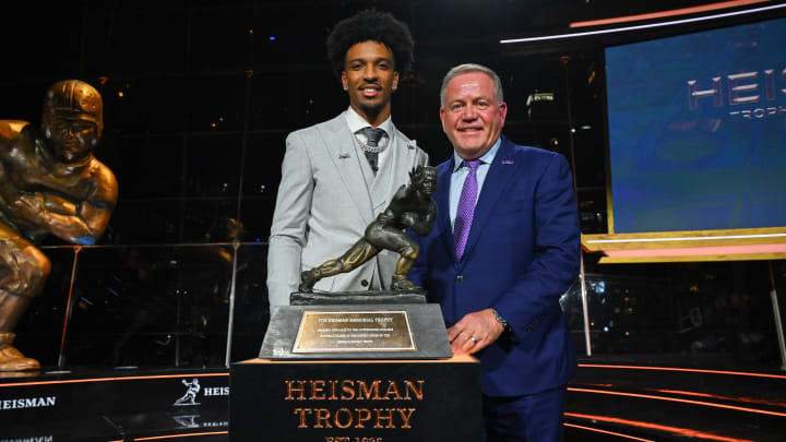 Dec 9, 2023; New York, New York, USA; Jayden Daniels poses with LSU coach Brian Kelly after winning the Heisman Trophy in the Astor ballroom at the New York Marriott Marquis. Mandatory Credit: Todd Van Emst/Heisman Trust/Pool-USA TODAY Sports